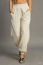 Cream-colored umgee drawstring jogger pants with elastic waistband tapered cuffs and front seam detail for casual wear