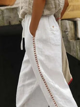 White linen cropped pants with delicate hollow out trim embroidered along the side seam for an elegant look