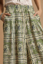 Umgee bohemian print wide-leg pants in green with cream and navy blue paisley design and pockets