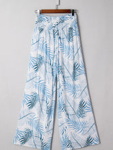 White wide-leg pants with vibrant blue tropical print and shirred waistband for stylish tropical print shirred look