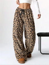 Beige leopard wide leg plush pants featuring a black drawstring waistband and soft comfortable material