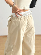 Beige cargo wide leg pants with white elastic waistband drawstring large side pockets and bow tie details