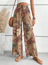Printed wide leg pants with vibrant paisley pattern in earthy beige red and green on lightweight fabric