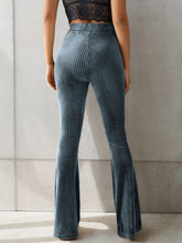 High-waisted blue velvet flare pants with vertical ribbed texture showcasing luxurious velvet flare style