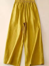 Golden-yellow wide-leg pants featuring a soft flowing fabric elastic waistband and button decoration