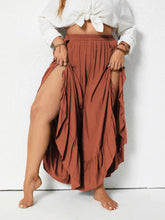 Rust-colored plus size ruffled wide leg pants with flowing fabric, ruffled hem, and side slits for a stylish look