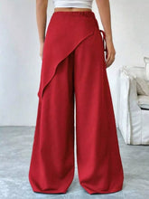 Red wrap-front wide-leg pants featuring a draped asymmetrical design and elastic waistband for stylish comfort