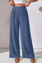 Blue pleated wide-leg pants with solid color textured fabric and a crossed waist design for a loose fit