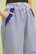 Umgee stripe scallop hem wide leg pants featuring blue and white vertical stripes with a royal blue scalloped pocket flap