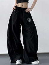 Black wide leg drawstring pants with heart-shaped embroidered patch on the thigh in soft fabric