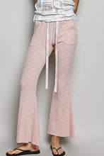 Soft pink ribbed knit pants with textured ribbed knit fabric, white drawstrings, and side pockets from pol collection