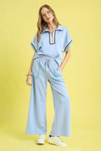 Light blue polo-style top with colorful embroidered trim paired with umgee drawstring wide leg pants with scallop trim detail