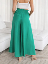 Emerald green wide leg pants with high waist wide leg cut and a ruffled elastic waistband with pockets