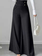 Black high waist wide leg trousers with a sleek satin finish and decorative silver buttons at the waistband