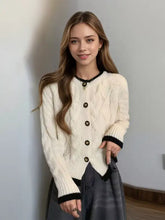 Strickjacke mit Zopfmuster in Creme mit schwarzem Besatz und goldenen Knöpfen