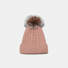 Pink cable knit winter hat with brown and white faux fur pom-pom