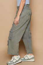 Distressed olive green wide leg cargo jeans in premium cotton denim with frayed edges and multiple pockets