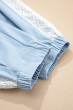 Light blue cotton wide leg slouchy pants with lace accent floral trim along the cuffs and patched pockets