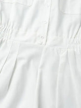White button-up romper with pleated skirt, elastic waist, machine wash cold