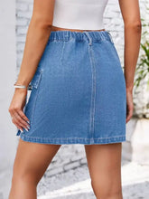 Casual cargo denim skirt in blue denim with elastic waistband mid-thigh length and a single side pocket for cargo denim style