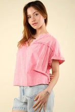 Woman in casual fit pink notched short sleeve top in washed knit fabric