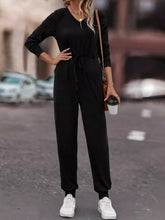 Black long-sleeved v-neck jumpsuit with drawstring waist, machine wash cold