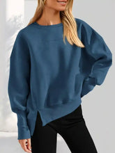 A soft teal oversized knit sweatshirt with relaxed fit and asymmetrical hemline machine wash cold recommended