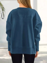 A teal oversized casual loose side slit sweatshirt with ribbed cuffs machine wash cold recommended