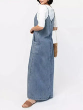 Light blue denim maxi dress with two front pockets and white top underneath casual washed denim cami maxi dress
