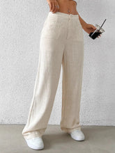 Beige linen wide-leg pants with a high waist and front pockets for a comfortable and stylish fit