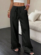 Black pleated tied wide leg pants with a drawstring waistband ideal for stylish comfort and versatility