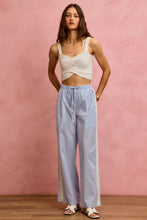 A pair of light blue and white wide check pants with a drawstring waistband and side lace trim and piping