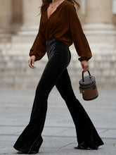 Brown velvet bucket bag with black leather handle and trim paired with high waist velvet flare pants