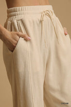 Cream-colored Umgee drawstring wide leg pants with ribbed texture and elastic waistband for comfortable wear