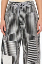 Black and white striped wide-leg pants with a gray drawstring waistband designed for comfortable casual wear