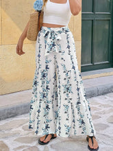 White floral print tie front wide leg pants with tied waistband and tiered hem for a stylish look