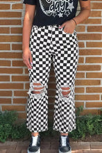 Black and white checkered print denim jeans with distressed details raw edges and ripped knee details cropped style