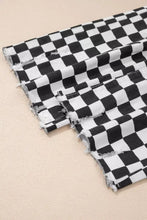 Black and white checkerboard print denim shorts with distressed details and raw edges featuring frayed hems