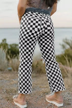 Checkerboard print black and white denim jeans with distressed details raw edges and cropped fit