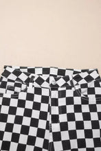 Checkerboard print denim jeans featuring distressed details, raw edges, cropped length, and classic button closure