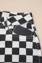 Black and white checkerboard print denim jeans with distressed details raw edges and a phone in the front pocket