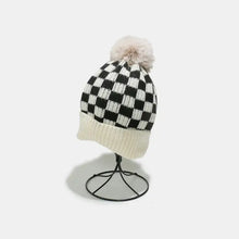 Black and white checkered knit hat with fluffy pompom