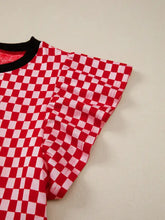 Red and white checkered print ruffle cap sleeve top with black ribbed neckline and round neck design