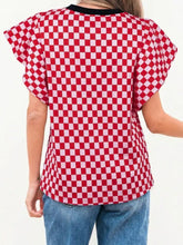 Red and white checkered print ruffle cap sleeve top with black ribbed contrast trim and round neckline