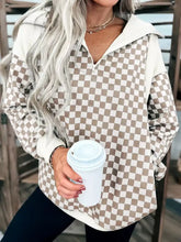 Beige and white checkered quarter zip sweatshirt with slightly stretchy fabric and machine wash convenience