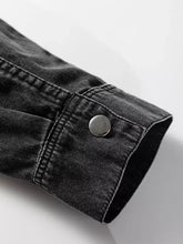 Black denim jacket sleeve with silver button and reinforced stitching on raw hem chest pocket shirt dress