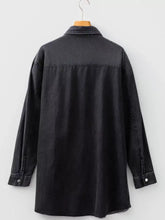 Black denim shirt dress with raw hem, chest pocket, relaxed fit, and buttoned cuffs in soft denim fabric