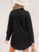 Black denim shirt dress with long sleeves buttoned cuffs chest pocket and raw hem for a loose fit style