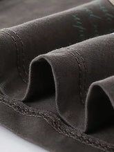 Dark gray denim edge with green cursive stitching on cartoon rabbit print t-shirt