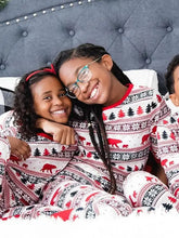 Two young girls in matching Christmas long sleeve pajama pants set